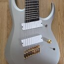 Šedo-bílá elektrická kytara s šesti strunami a tmavým hmatníkem. Nástroj má dva bílé humbuckery, zlatý ovládací knoflík a zlatý kobylník. Povrch těla…