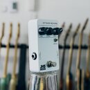 Bílý efekt pedál s nápisem OCTAVE REVERB. Na horní straně jsou tři černé ovládací knoflíky s popisky VERB, OCTAVE a DECAY, dále přepínač s nápisem UP…