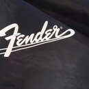 Detail černé textilní brašny nebo obalu. Na povrchu je bílý nápis Fender s registracní značkou ®. Materiál vykazuje mírné pomačkání.