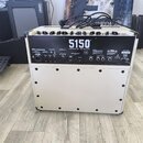 Zadní strana bílého kytarového komba. Na horním černém panelu je bílý nápis 5150 ICONIC SERIES a logo EVH. Panel obsahuje různé ovládací prvky, konek…