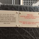 Detail dvou kovových štítků připevněných na černý texturovaný povrch přístroje. Levý štítek obsahuje nápisy: 220 V ~ AC 50-60 Hz PN = 30 W, PA = 12,5…