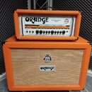 Kytarový zesilovač s oranžovým potahem, složený z hlavy a reproduktorové skříně. Na hlavě je nápis ORANGE a model ROCKERVERB 50 MK II, s řadou ovláda…