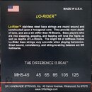Fotografie znázorňuje černé obalové sáčkování basových strun. Je na něm bílý nápis MADE IN U.S.A., žlutý text LO-RIDER™ a doprovodný popis produktu v…