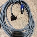 Šedý audio kabel smodulárním zakončením. Na jednom konci je modrý konektor XLR a na druhém černý panelový konektor. Na plášti kabelu je čitelný nápis…