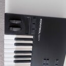 Černý MIDI kontrolér s klávesnicí. Na horním panelu je bílý nápis KONTROL S61 N a dva černé otočné knoflíky. Povrch přístroje je matný a v dobrém sta…