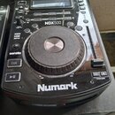 Černý DJ kontroler značky Numark s modelem NDX500. Zařízení obsahuje velký stříbrno-černý jogwheel, posuvník pitch bend a řadu tlačítek s nápisy jako…