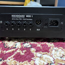Černý patchbay s nápisem ROCKBOARD MOD 1 by WARWICK All-In-One TRS + XLR Patchbay. Zařízení obsahuje pět vstupů označených písmeny A, B, C, D, E a je…