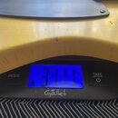 Černá digitální váha značky Gallet s modrým displejem, který ukazuje hodnotu 3111 kg. Na váze jsou tlačítka s nápisy MODE a TARE spolu s ikonou zapnu…
