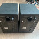 Dva černé studiové monitory značky YAMAHA. Na zadní stranách jsou viditelné nápisy POWERED MONITOR SPEAKER, MODEL HS5 a YAMAHA CORPORATION MADE IN CH…