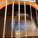 Detail vnitřní štítku akustické kytary s dřevěnou deskou. Na štítku jsou uvedeny nápisy STYLE FT110, Masterbilt Frontier, EPIPHONE a No. 25092302380.…