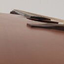 Detailní pohled na spodní část dopadu strun akustické kytary s hnědým povrchem. Je vidět tmavý most s šesti černými kolíky. Na nástroji nejsou žádné…