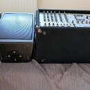 Čtyři černé reproduktory v bednách potažených tmavým povrchem. Jeden z nich obsahuje integrovaný mixážní panel s knoflíky a posuvníky, na kterém je v…