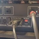 Zadní panel černého hudebního zesilovače s různými konektory a přepínači. Jsou zde viditelné nápisy FX SEND, FX RETURN, RECORD OUT a sekce MIDI s pop…