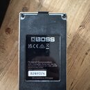 Zadní strana černého efektového pedálu značky BOSS. Na spodním štítku je uveden nápis Roland Corporation, adresa v Japonsku a text MADE IN MALAYSIA.…