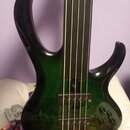 Tmavě zelená elektrická basová kytara s čtyřstrunným hmatníkem. Nástroj má dva snímače typu humbucker a tři ovládací knoflíky. Na těle nejsou viditel…