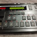 Černý vokálový procesor s nápisem VOCALIST VHIMS a logem DigiTech. Zařízení má digitální displej, červené LED diody a řadu ovládacích tlačítek s ozna…