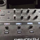 Detailní pohled na ovládací panel mixeru značky DENON DJ. Panel obsahuje sekce MIC 1 a MIC 2 s ovládacími prvky LEVEL, LOW, MID a HIGH, dále sekci FX…
