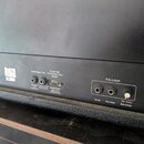 Záběr na zadní panel černého kytarového komba. Jsou zde vidět konektory s nápisy FOOTSWITCH, CUSTOM FOOTSWITCH PORT a F.X.LOOP (SEND, RETURN). U port…