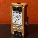 Zadní strana efektového pedálu v zlaté barvě. Na bílém štítku je uveden nápis VALETON, Adapter: 9V, Polarity: (symbol polarity), Made in China, CE a…