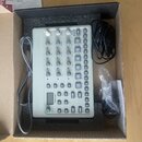 Světle šedý sampler ModelCycles značky Elektron v originální krabici s pěnovou vložkou. Na zařízení jsou vidět nápisy Elektron a ModelCycles spolu s…