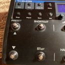 Černý efektový procesor s nápisem TCHELICON v horní části. Zařízení má několik tlačítek s popisky Tone, Pitch (pod ním nápis Hold to Edit), Guitar FX…