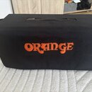 Černý textilní kryt na hudební zařízení s rukojetí v horní části. Uprostřed je vyšívaný oranžový nápis ORANGE. Povrch materiálu je v dobrém stavu bez…