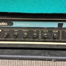 Čelní panel kytarového zesilovače s nápisy acoustic a MODEL 114. Na pravé straně je nalepený štítek s textem SERVAAS' MUZIEKHANDEL B.V. a logem M. Pa…