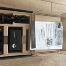 V kartonové krabici s vložkou je umístěn černý elektronický přístroj s displejem a nápisy ADI a myDtx GO. Součástí sady je černý napájecí kabel s USB…