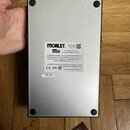 Spodní strana šedého efektového pedálu s čtyřmi gumovými nožičkami. Uprostřed je bílá nálepka s nápisy MORLEY, M2 a textem This pedal is PASSIVE no a…