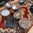 Sada bubnů v hnědém lesklém provedení s kovovým hardwarem. Na blanách je viditelné logo TAMA. Soubor obsahuje snare, dva tom-tomy, floor tom a basový…