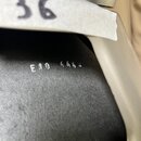 Detailní pohled na černý povrch nástroje. Na povrchu je bílým nápisem uvedeno E10 4442. V horní části je vidět bílý papírový štítek s ručně napsaným…