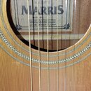 Detail akustické kytary s viditelným vnitřním štítkem. Na štítku je uveden nápis ACOUSTIC GUITAR, hand crafted, značka MARRIS a text MADE BY MARRIS L…