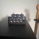 Černý kytarový efekt s kovovým povrchem. Na zadní straně jsou čtyři jack konektory a vstup pro napájení s nápisy IN L/MONO, RIGHT (RETURN), OUT L/MON…