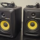 Dva černé studiové monitory s žlutými membránami basových reproduktorů. Na přední straně každého reproduktoru je bílý nápis KRK Global Sonic a žlutoz…
