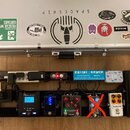 Stříbrný hliníkový kufr s různými nálepkami, včetně nápisů SPACESHIP, TONERIDER a KingTone. Pod kufrem je černý pedalboard s napájecím trafem Caline…