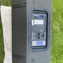 Zadní strana černého aktivního reproduktoru s texturovaným povrchem. Na ovládacím panelu je nápis Electro-Voice a ETX Powered Loudspeaker. Panel obsa…