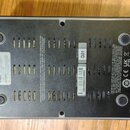 Fotografie zachycuje spodní stranu šedého elektronického zařízení s ventilačními otvory. Na povrchu jsou nápisy „DESIGNED IN MOUNTAIN VIEW, USA - MAN…