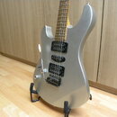 Stříbrná elektrická kytara s jasným povrchem a hnědým hmatníkem. Nástroj má tři černé humbuckery, tremolo páku a dvě ovládací knoflíky. Kytara je umí…
