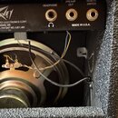 Zadní strana kytarového komba s černým povrchem. Na horním panelu jsou tři konektory s nápisy HEADPHONE, PREAMP OUT a REMOTE SWITCH, doprovázené loge…