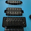 Modrá elektrická kytara se třemi snímači, z nichž každý nese bílý nápis Seymour Duncan. Nástroj je vybaven černým tremolo mechanismem s nápisem Floyd…