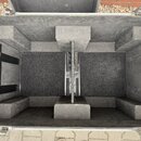 Otevřený transportní kufr s hliníkovým profilem a černým povrchem. Vnitřek je vyložen tmavou pěnou s výřezem rozděleným na dvě části. Na vnitřní stra…