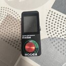Černý kompaktní efekt s displejem a červeným ovládacím knoflíkem. Na přístroji jsou nápisy Speaker CAB Simulator, Radar a MOOER. Nad knoflíkem je vid…