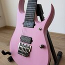 Růžová elektrická kytara s matným povrchem a černým hmatníkem. Je vybavena dvěma černými snímači (single-coil u kobylky a humbucker v pozici krku) a…