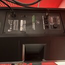 Zadní strana černého reproduktoru s nápisem THUMP 15BST a logem JBL. Jsou vidět připojovací konektory, vypínač a štítek s technickými údaji, kde je u…
