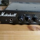 Černý kytarový zesilovač s bílým nápisem Marshall. Na předním panelu je vstup INPUT a sekce RHYTHM MODE s knoflíky označenými jako DRIVE, R2 VOICE a…