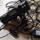 Černý digitální nahrávací zařízení s displejem a ovládacími prvky, na kterém je nápis Roland RO-04. K zařízení patří několik černých kabelů různých t…