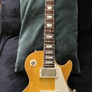 Elektrická kytara s žlutým povrchem těla a hnědým hřednicí. Na hlavě je viditelné logo Gibson a podpis Jimmy Page. Kytara je vybavena dvěma humbucker…