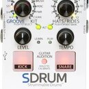 Bílý efekt pedál s nápisem SDRUM Strummable Drums™. Zařízení obsahuje dva hlavní ovládací knoflíky s popisky GROOVE KIT a HATS/RIDES, dva menší knofl…