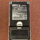 Zadní strana efekt pedálu v kovovém šasi. Na černém štítku je nápis Maxon, značka CE a text MADE IN JAPAN FABRIQUE AU JAPON. Pod logem je uveden kód…