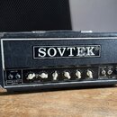 Kytarový zesilovač v černém vinylovém potahu s kovovými hranami. Na předním panelu je velký nápis SOVTEK® a vpravo dole označení SOVTEK® MIG-50. Vlev…